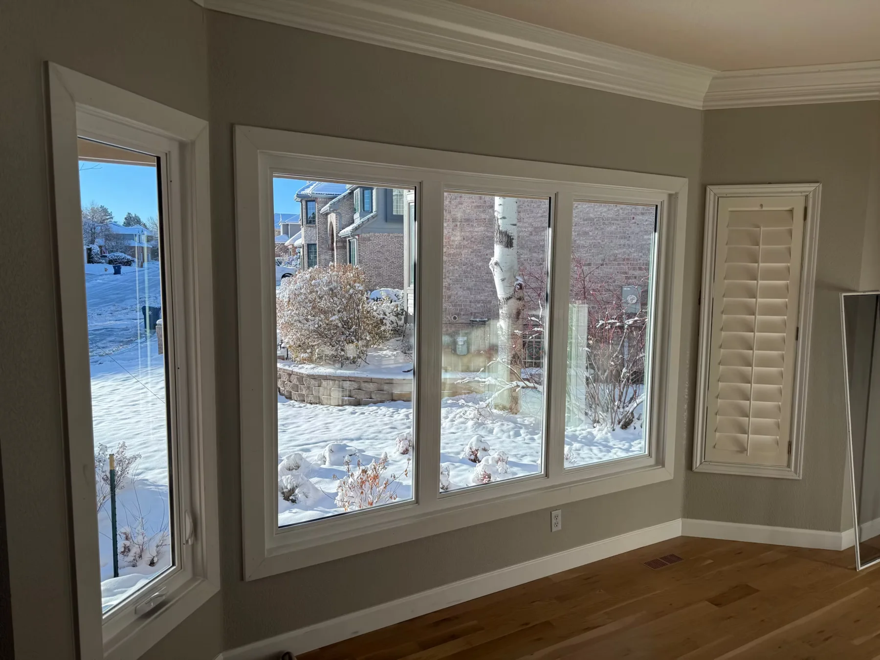 Living room with picture windows overlooking a snowy Colorado neighborhood